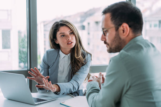 Two professionals discussing business plans in a modern office setting in Dubai.