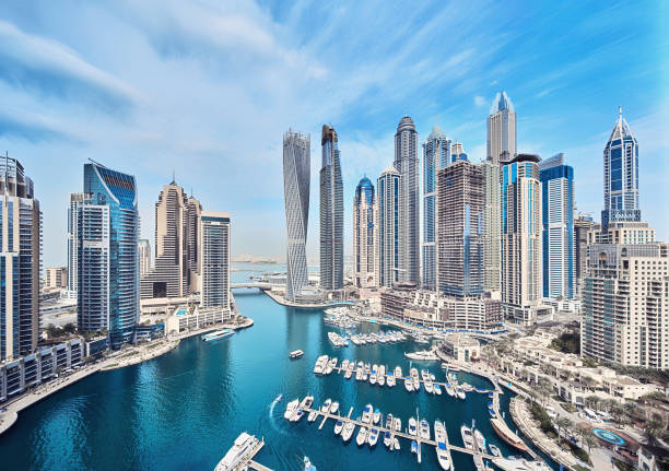 Aerial view of Dubai Marina with skyscrapers and waterfront, contrasting different free zones including DMCC.