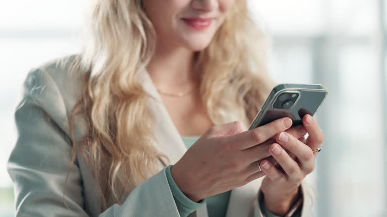 A woman in a business suit uses her smartphone, symbolizing global trade connectivity at DMCC Dubai.