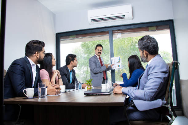 Business professionals discussing charts and data in a meeting room, highlighting key industries in DMCC Dubai.