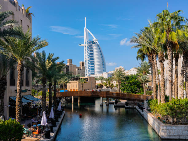 Palm-lined canal with iconic Burj Al Arab in Dubai skyline highlights city's unique free zone destinations.